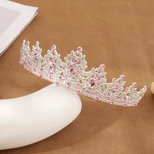 Detailed view of silver bridal crown with pink crystals and shimmering rhinestones
