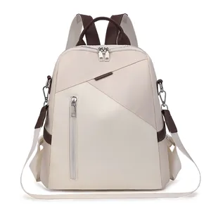 Close-up of beige nylon backpack featuring brown accents and detachable shoulder strap