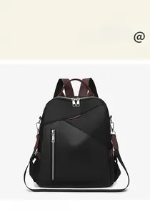 Detail view of stylish nylon backpack with brown leather handle and zipper accents