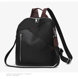 Detail of nylon and brown leather stitching on a black backpack with silver zippers