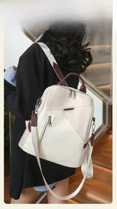Detail shot of a stylish contrasting backpack worn by a model in a modern staircase setting