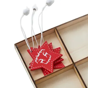 Red wooden star Christmas tree ornaments with white reindeer print in wooden box.