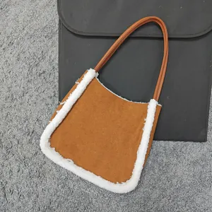 Overhead view of a brown faux suede shoulder bag with white fleece trim on grey rug
