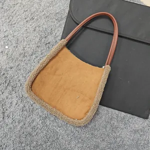 Detailed view of camel faux suede shoulder bag with fleece trim and dark brown handles