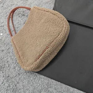 Detail of the soft tan sherpa faux fur texture and leather handle on this tote bag