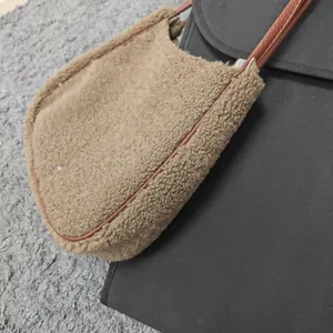 Detail of a brown fuzzy sherpa shoulder bag featuring soft plush texture and slim leather strap