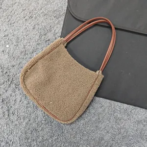 Detail shot of camel fleece tote bag showing plush texture and dark leather handles