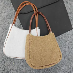 Detailed view of white and camel faux shearling tote bags with brown leather straps
