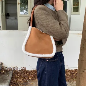 Brown suede shoulder bag with thick white faux shearling trim and long leather handles