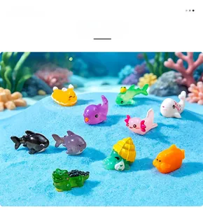 Assortment of miniature colorful resin sea animal figurines displayed on blue sand