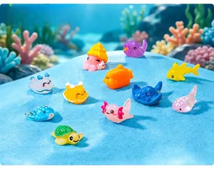 Macro detail showing colorful cartoon resin marine animal figurines on blue sand
