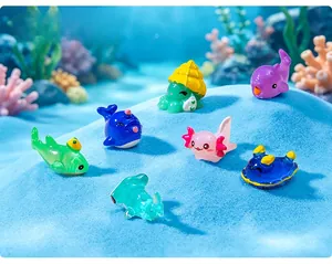 Detail showing a collection of colorful miniature marine animal figurines on blue sand