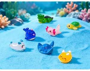 Detailed view of colorful miniature resin sea animal figurines on blue sand background