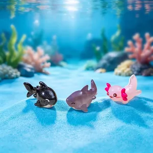 Miniature resin marine animal figurines including sharks and axolotl on blue sand