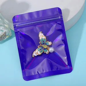 Detailed view of an iridescent laser film seal bag protecting a butterfly jewelry brooch
