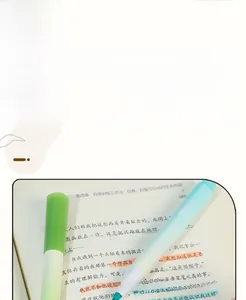 Macro detail of a soft pastel dual-tip highlighter pen marking text on a book page