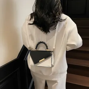 Borsa a mano minimalista bicolore bianco e nero con manico intrecciato e dettagli oro