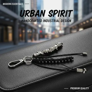 Detailed view of handcrafted industrial metal keychain with black beads on leather