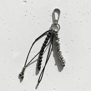 Detailed view of niche irregular metallic beads and black stone beaded bag charm