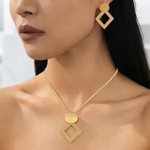 Detail view of a 18K gold geometric jewelry set featuring a necklace and drop earrings
