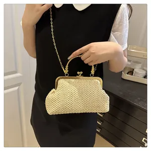 Detail of cream woven shell bag with gold clasp closure and metallic chain strap