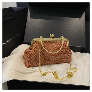 Detail of reddish-brown woven shell bag with gold chain and vintage metal ball clasp