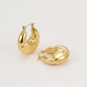 Detailed macro shot of vintage textured gold-plated chunky C-shaped hoop earrings