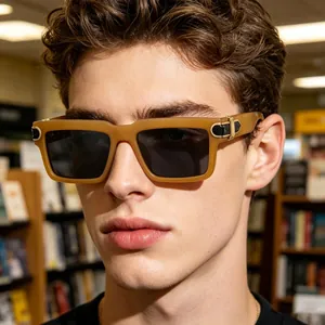 Close-up of a stylish male model wearing tan square frame sunglasses with gold hinge