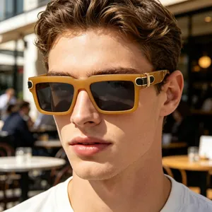 Close-up of a man wearing fashionable tan square sunglasses in an outdoor setting