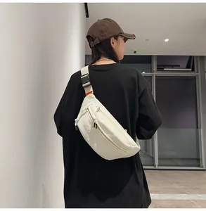 Vista posteriore del modello con borsa a tracolla in nylon bianco e cinghia