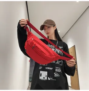 Dettaglio borsa a tracolla rossa in nylon con doppia cerniera e spallina regolabile in tessuto