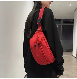Vista posteriore di una borsa a tracolla in nylon rosso con cinghia regolabile su modello