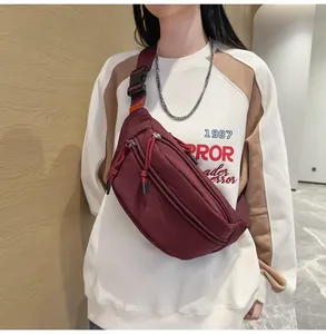 Vista dettagliata del marsupio in nylon bordeaux con tre tasche e tracolla regolabile