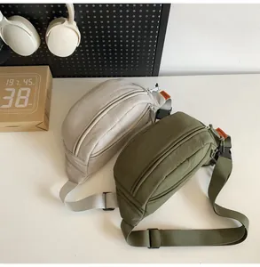 Dettaglio dei borselli a tracolla in nylon impermeabile beige e verde oliva con etichette