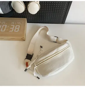 Dettaglio del marsupio in nylon bianco impermeabile con etichetta arancione e fibbia nera