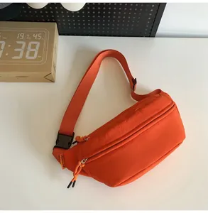 Vista dettagliata del borsello monospalla in nylon arancione con doppia zip e fibbia