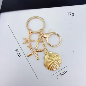 Gold ocean themed keychain with starfish and pearl shell charms with size detail