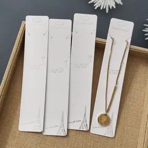 Golden stainless steel coin necklace displayed on a white jewelry cardboard holder