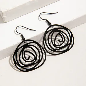 Detailed close-up of black irregular spiral circle dangle earrings on white blocks