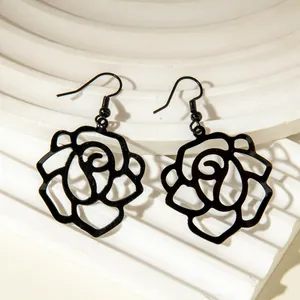 Close-up view of elegant black hollow-out rose flower dangle earrings with hooks