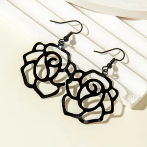 Detailed close-up of elegant black hollow rose flower silhouette drop earrings