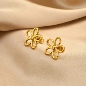 Gros plan de boucles d'oreilles puces en forma de fleur évidée en acier inoxydable doré