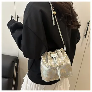 Detailed side view of New Chinese style bucket bag featuring pearl handle and gold embroidery