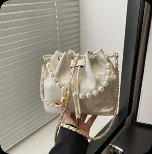 Elegant New Chinese style pearl bucket bag with drawstring and gold chain strap.