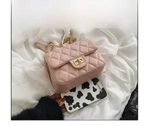 Close-up of pink quilted crossbody bag showing metal chain and twist-lock detail
