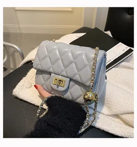 Detail of light blue quilted leather bag showing gold hardware and ball chain adjuster