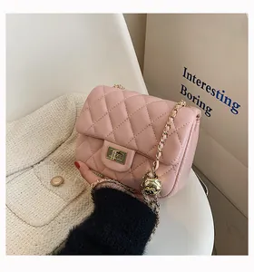 Detail of pink quilted handbag with golden ball chain adjuster and classic metal lock