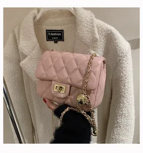 Detailed macro view of pink quilted leather bag with golden adjustable ball and chain
