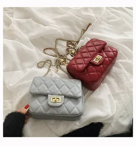 Macro detail of diamond quilted faux leather and gold metal clasp on chain bags