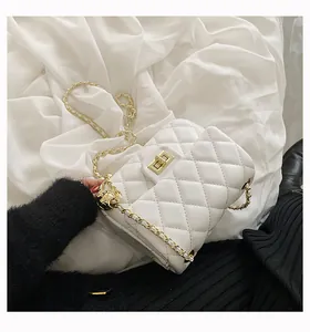 Close-up of white quilted leather bag with gold metal chain strap and twist-lock clasp